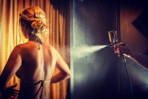 Woman being spray tanned at OATS SLO tanning & airbrush Salon