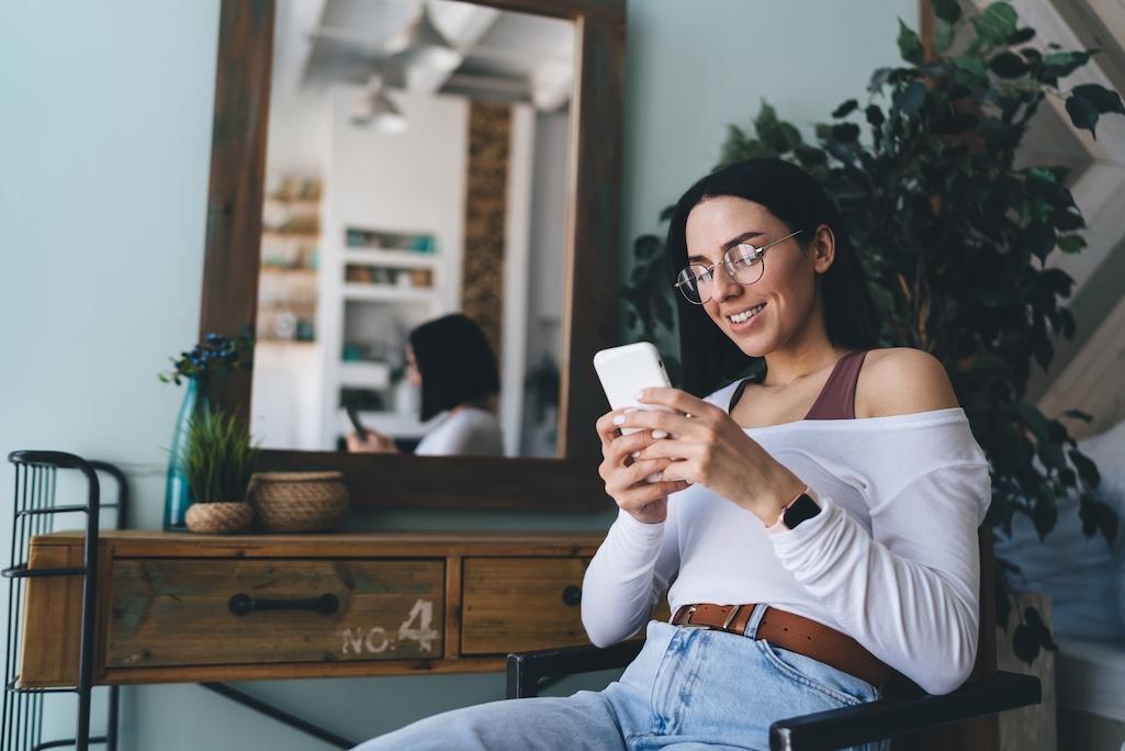 cheerful-woman-using-smartphone-at-home-2025-03-25-00-53-14-utc.jpg