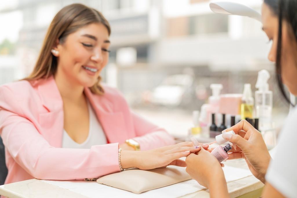 smiling-client-in-a-beauty-salon-painting-her-nail-2025-03-06-00-09-02-utc.jpg