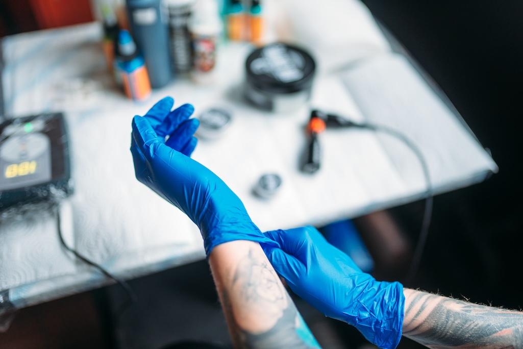 female-tattoo-artist-hands-in-blue-sterile-gloves-2024-11-26-13-15-26-utc.jpg